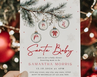 Op de afbeelding: Een witte babyshower-uitnodiging met een aquarel-illustratie van een dennentak met ornamenten. De ornamenten zijn versierd met babyartikelen zoals een hoed, een rompertje en slofjes. De tekst op de uitnodiging luidt "Santa Baby" en bevat de datum en tijd van de babyshower, de naam van de jarige en de RSVP-informatie.