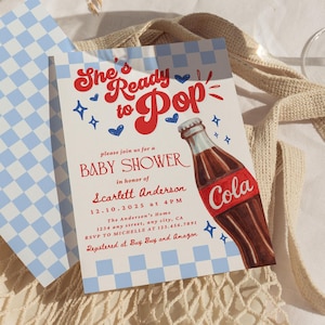 May include: Baby shower invitation with the text "She's Ready to Pop" and a cola bottle illustration. The invitation is on a white background with blue checkered accents. A slice of papaya and a glass of water are also visible.