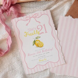 May include: A rectangular birthday invitation card with a pink and white striped border, featuring a pink bow at the top, a watercolor lemon illustration, and the text She's Freshly 21, Bianca 21st Birthday, 12.10.2024 at 4PM, The Foxy Bar, 123 any street, any state, 12345, Rsvp to Bianca at 123.456.7891.