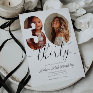 May include: A white invitation card with black text announcing a 30th birthday party for Julia. The card features a photo of a young girl and a woman, both looking at the camera, with the number 30 cut out of the photo and the word "thirty" written in cursive.