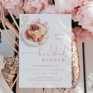 Peut inclure: Une carte blanche avec du texte rose annon&ccedil;ant un brunch de mariage pour Samantha Morris le 10 d&eacute;cembre 2024 &agrave; 16h00. La carte pr&eacute;sente une illustration aquarelle d'une assiette de cr&ecirc;pes avec des baies et un verre de vin blanc.