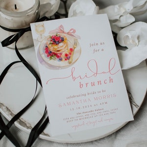 Peut inclure: Une invitation &agrave; un brunch de mariage rose et blanche avec une illustration aquarelle d'une assiette de cr&ecirc;pes aux baies et d'un verre de champagne. L'invitation comprend le texte "join us for a bridal brunch", "celebrating bride to be Samantha Morris", "12.10.2024 at 4PM", "The Pancake Palace", "1234 any street, any city, any state, 12345", "RSVP to Michelle at 123.456.7891", et "registered at Target and Amazon".
