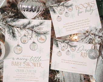 May include: Baby shower invitations and cards with a winter theme. The invitations feature text and illustrations of baby-related items. The cards are decorated with snowflakes and silver ornaments. The background is a decorated Christmas tree.