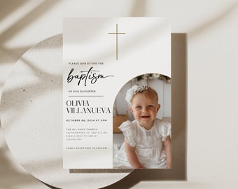May include: A white baptism invitation with a gold cross at the top. The invitation says "Please join us for the baptism of our daughter Olivia Villanueva" and includes the date and time of the baptism. A photo of a baby girl in a white dress is in the bottom right corner of the invitation.