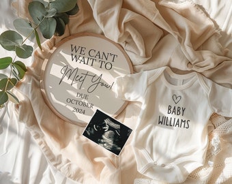 May include: A white baby onesie with the text "Baby Williams" and a heart design. A wooden sign with the text "We can't wait to meet you! Due October 2024" and a sonogram photo.