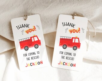 May include: Two white gift tags with a red fire truck illustration. The tags read "THANK you!" and "FOR COMING TO THE RESCUE!" with the name "JACKSON" at the bottom. Each tag is strung with twine.