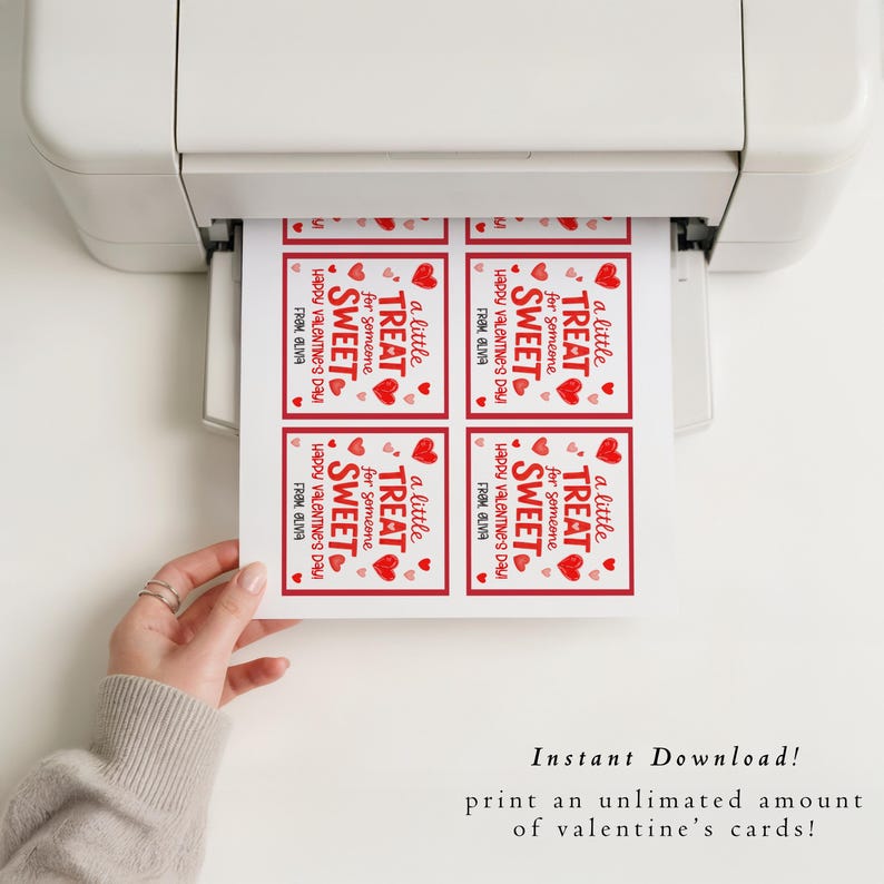 May include: A printer is shown printing Valentine's Day cards. Each card has a red border and features the text "a little TREAT for someone SWEET Happy Valentine's Day! FROM OLIVA" with heart illustrations. The image also includes the text "Instant Download! print an unlimited amount of valentine's cards!"