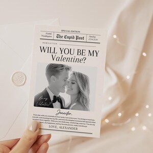 May include: A Valentine's Day card with the headline "Will You Be My Valentine?" in a newspaper-style design. The card includes a black and white photo of a couple. An envelope with a wax seal is also visible. The text "The Cupid Post" is at the top.