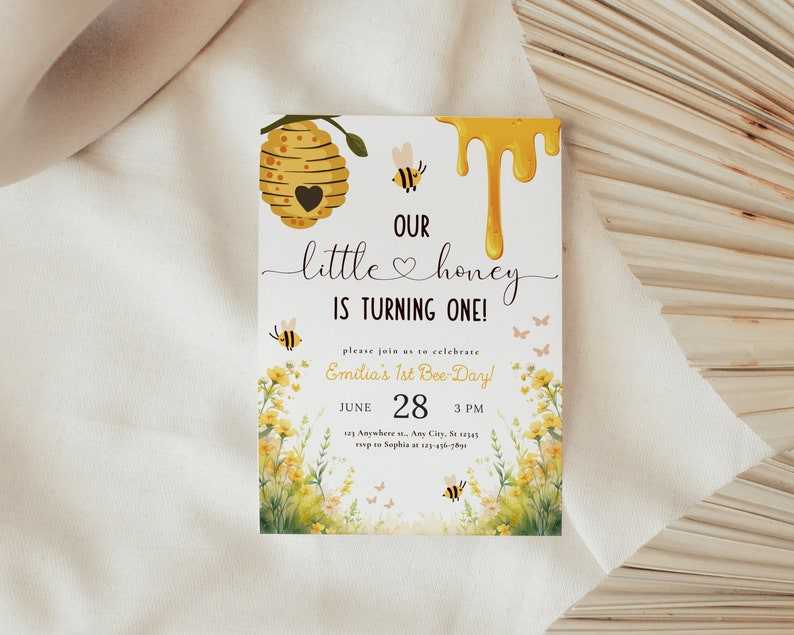 May include: A yellow and white bee-themed baby shower invitation with a honeycomb, dripping honey, and bees. The text reads "Our little honey is turning one!" and "Emilia's 1st Bee-Day!" with the date and time of the party.