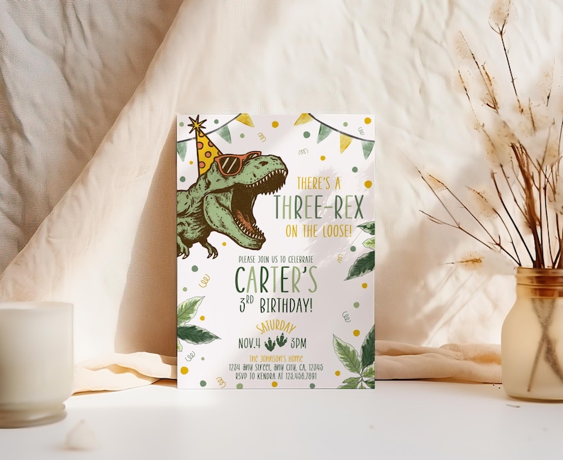 May include: A birthday invitation featuring a green dinosaur wearing sunglasses and a party hat. The text reads "There's a Three-Rex on the Loose!" and announces Carter's 3rd birthday on November 4th at 5 PM. Decorative elements include leaves and confetti.