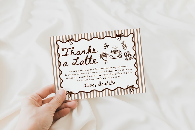 Peut inclure: Une tasse en c&eacute;ramique blanche avec une anse noire et le texte "But First, Coffee" en noir. La tasse, remplie d'un liquide fonc&eacute;, repose sur une surface en bois.