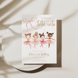 May include: A pink and white invitation card with a pink ribbon bow and four ballerina girls in pink tutus. The text on the card reads "Victoria is tutu cute" and "Victoria's 2nd Birthday".