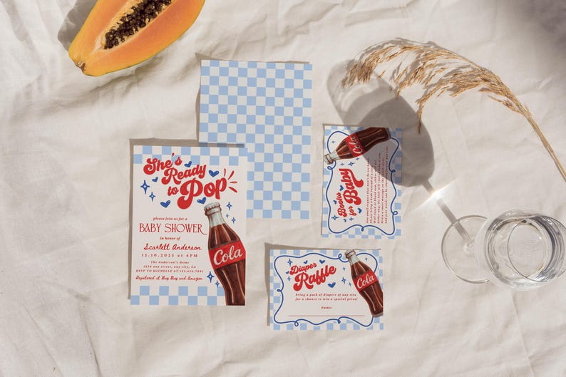 Może przedstawiać: Zestaw papeterii na baby shower z motywem butelki coli w stylu retro. Zaproszenie głosi "She's Ready to Pop" z niebiesko-białym wzorem w kratkę. Plasterek papai widoczny jest w lewym g&oacute;rnym rogu.