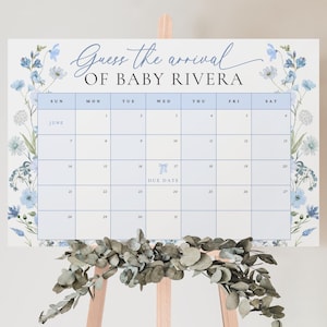 May include: A blue and white floral themed baby shower game with a calendar for guests to guess the arrival date of Baby Rivera. The due date is circled on the calendar.