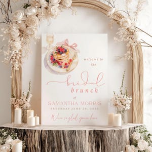 Könnte beinhalten: Ein weißes Schild mit rosa Text und einer Aquarellillustration von Pfannkuchen, Beeren und einem Glas Champagner. Auf dem Schild steht "welcome to the bridal brunch of Samantha Morris, Saturday June 20, 2025. We're so glad you're here."