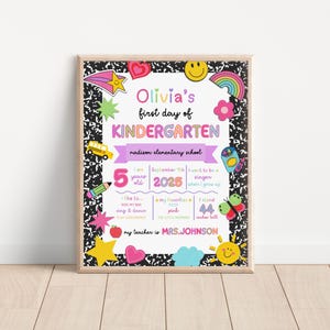 K&ouml;nnte beinhalten: Ein gerahmtes, farbenfrohes Kindergarten-Schild mit dem Text "Olivia's first day of KINDERGARTEN". Das Schild enth&auml;lt dekorative Elemente wie Sterne, Herzen und einen Schulbus. Es listet auch das Alter des Kindes, das Datum und andere pers&ouml;nliche Details auf.