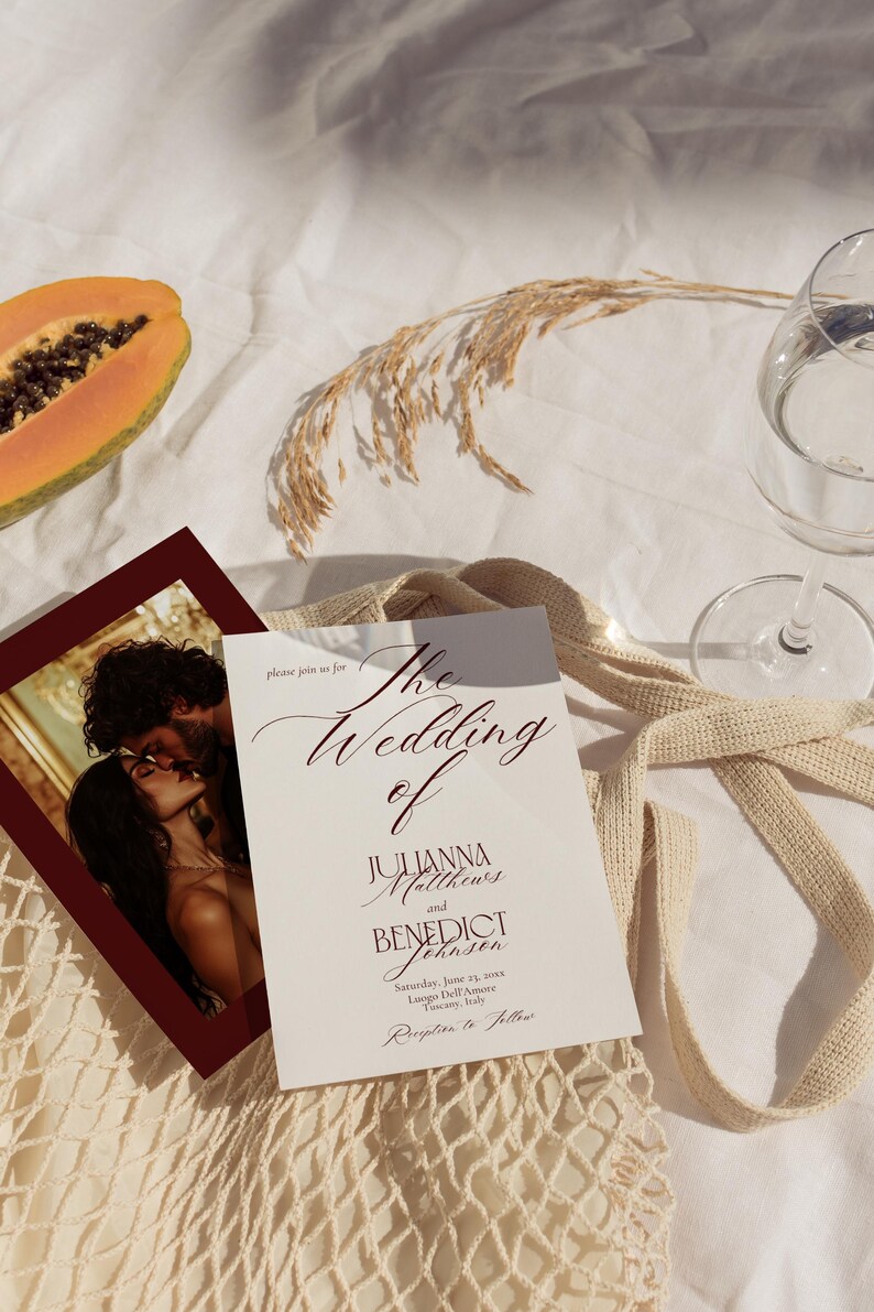 May include: Wedding invitation with the text "The Wedding of Julianna Matthews and Benedict Johnsen". The invitation is on a white background with a photo of a couple kissing. A half papaya and a glass of water are also visible.