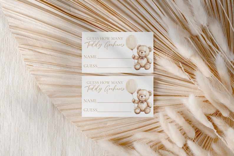 May include: Two rectangular cards with the text "Guess How Many Teddy Grahams" in a script font. Each card features a watercolor illustration of a teddy bear holding a balloon. The cards have lines for "Name" and "Guess".