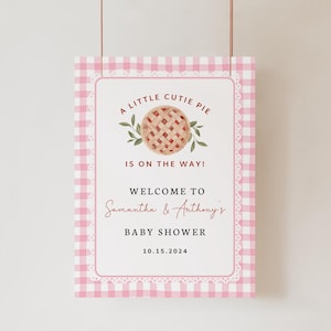 Puede incluir: Un letrero de baby shower rosa y blanco con estampado de cuadros vichy. Anuncia "A Little Cutie Pie Is On The Way!" y da la bienvenida al baby shower de Samantha & Anthony el 10.15.2024. Incluye un gr&aacute;fico de tarta.