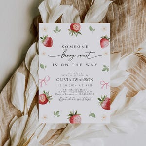 May include: A white baby shower invitation with a watercolor illustration of strawberries and greenery. The text reads "Someone berry sweet is on the way" and includes the details of the shower, including the date, time, location, and RSVP information.