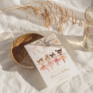 May include: A pink and gold invitation card with a watercolor illustration of four girls wearing tutus and dancing. The text on the card reads "Victoria is tutu cute" and "Please join us to celebrate Victoria's 2nd Birthday, October 14, 2014 at 1pm".