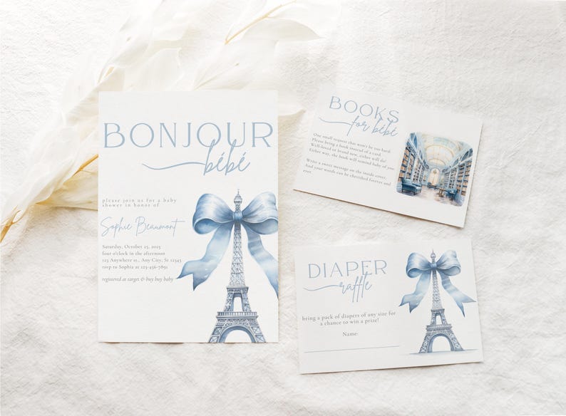 May include: A baby shower invitation featuring a blue and white Eiffel Tower design. The invitation reads "Bonjour B&eacute;b&eacute;" and includes the text "Please join us for a baby shower in honour of..." and "Saturday, October 15, 2023..."