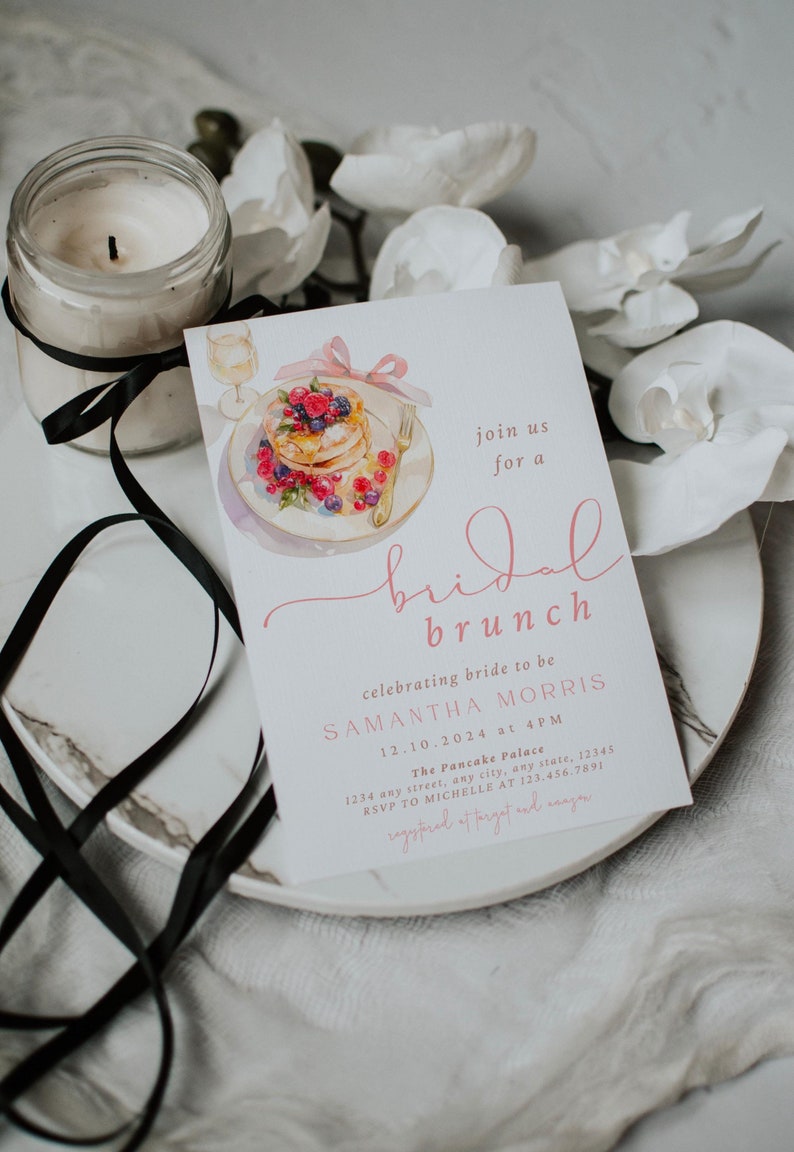 Peut inclure: Une invitation &agrave; un brunch de mariage rose et blanche avec une illustration aquarelle d'une assiette de cr&ecirc;pes aux baies et d'un verre de champagne. L'invitation comprend le texte "join us for a bridal brunch", "celebrating bride to be Samantha Morris", "12.10.2024 at 4PM", "The Pancake Palace", "1234 any street, any city, any state, 12345", "RSVP to Michelle at 123.456.7891", et "registered at Target and Amazon".