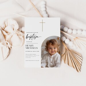 May include: A white card with a gold cross at the top. The text reads "Please join us for the baptism of our son Henry Michaels October 06, 2024 at 3pm The All Saint Church 123 Anywhere St. Seattle, WA Kindly RSVP to Ana at 123 456 7892 Lunch reception to follow". A photo of a baby boy is in the bottom right corner.