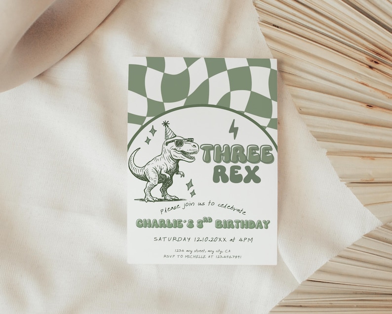 May include: A white invitation card with a green and white checkered pattern at the top. The card features a cartoon dinosaur wearing sunglasses and a party hat, with the text "THREE REX". The invitation is for Charlie's 3rd birthday.