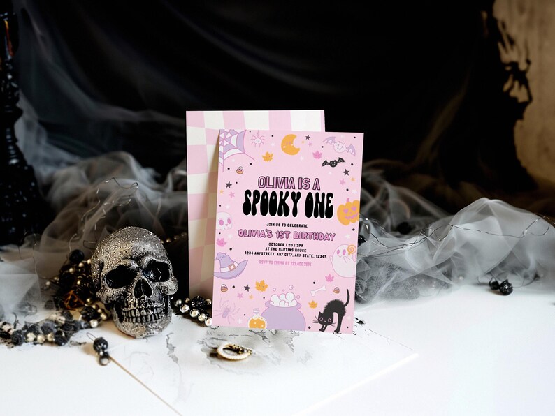 Puede incluir: Invitaci&oacute;n de cumplea&ntilde;os de Halloween de color rosa y morado con el texto "Olivia is a Spooky One" y "Olivia's 1st Birthday". La invitaci&oacute;n presenta un gato negro, un caldero y otras ilustraciones de tem&aacute;tica de Halloween.
