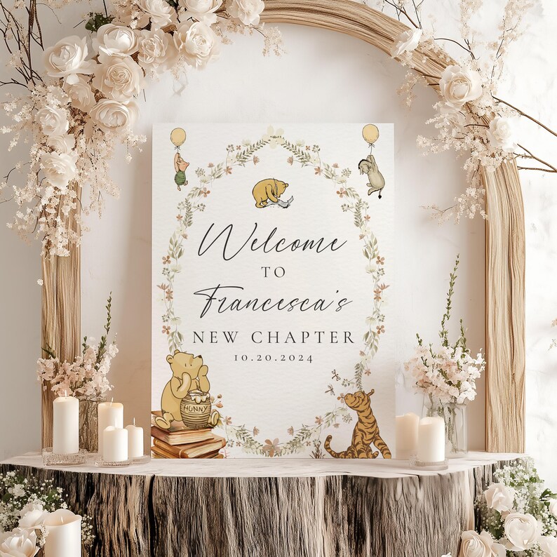 May include: A Winnie the Pooh themed welcome sign with a floral wreath and the text "Welcome to Francesca's New Chapter 10.20.2024". The sign features Winnie the Pooh, Piglet, and Tigger.
