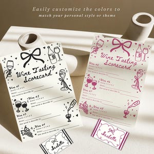 Pu&ograve; includere: Due schede di valutazione della degustazione di vini con illustrazioni di fiocchi e calici. Uno &egrave; in bianco e nero, l'altro rosa. Il testo "Wine Tasting Scorecard" &egrave; in alto. Piccole carte con il nome "Isabella" in basso.