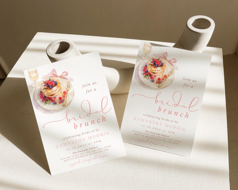 Peut inclure: Deux invitations de couleur rose et blanche pour un brunch de mariage avec une illustration aquarelle d'une assiette de cr&ecirc;pes avec des baies et un verre de champagne. Le texte sur les invitations indique "rejoignez-nous pour un brunch de mariage c&eacute;l&eacute;brant la future mari&eacute;e Samantha Morris".
