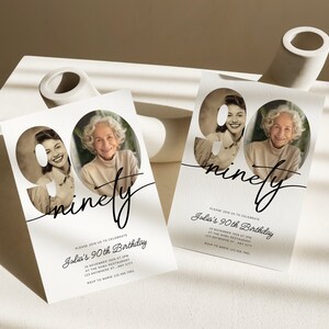 Puede incluir: Una tarjeta de invitaci&oacute;n blanca con una foto en blanco y negro de una mujer en el n&uacute;mero 90. El texto "ninety" est&aacute; escrito en cursiva. El texto "Please join us to celebrate Julia's 90th Birthday" est&aacute; impreso debajo del n&uacute;mero.