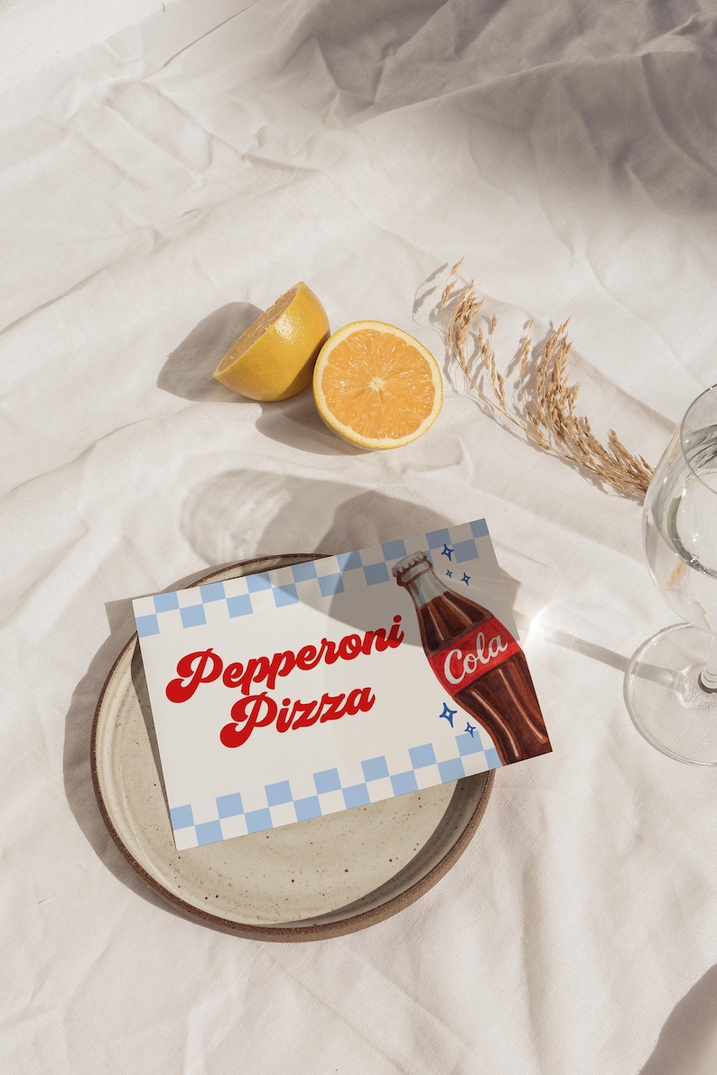 Może przedstawiać: Martwa natura z talerzem z kartą z napisem "Pepperoni Pizza" i ilustracją butelki coli. Karta ma niebiesko-biały wz&oacute;r w kratkę. Obecne są r&oacute;wnież dwie poł&oacute;wki cytryny i szklanka.