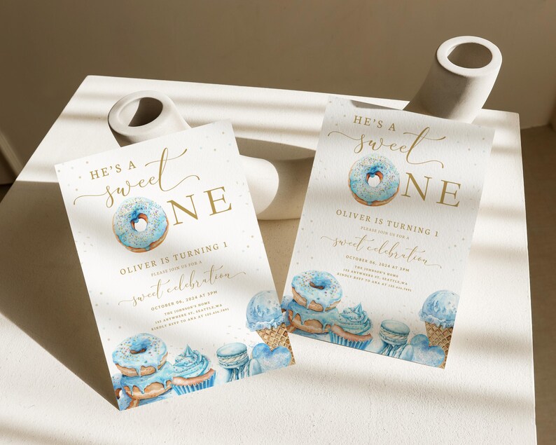 May include: Blue and gold donut-themed first birthday party invitation with the text "He's a Sweet One" and the name "Oliver".