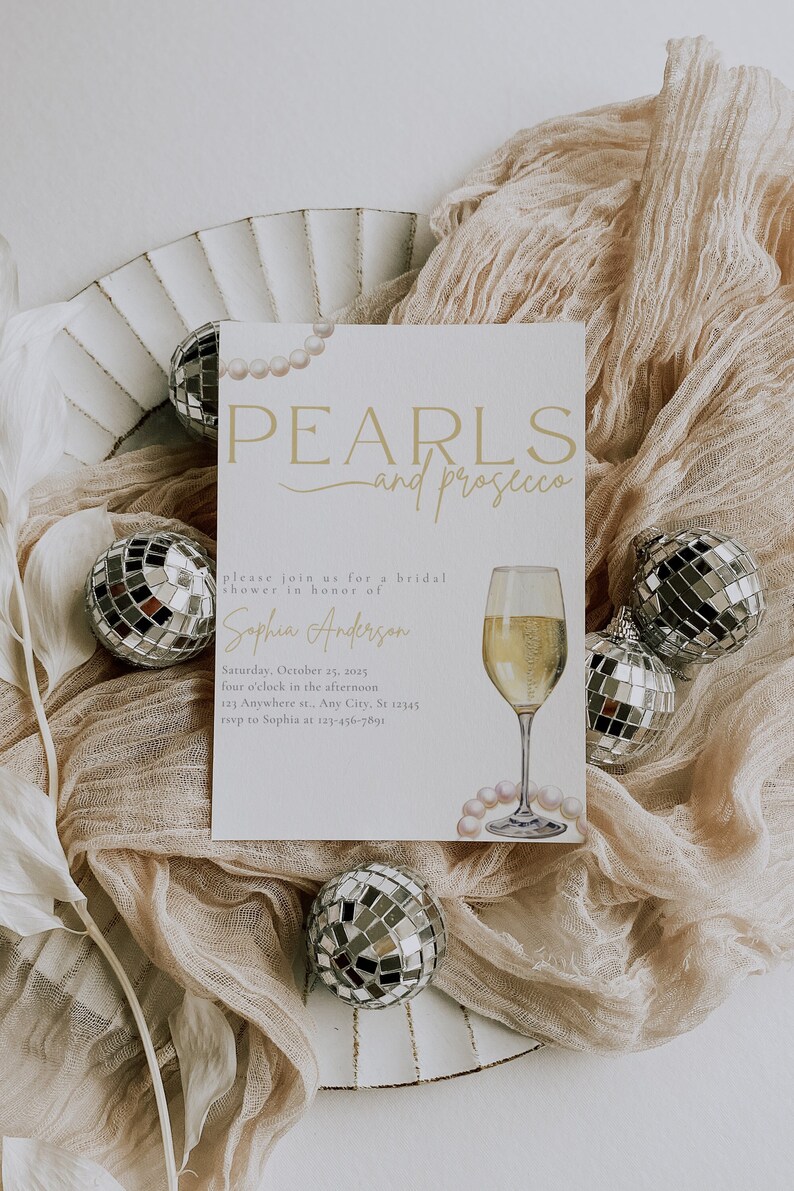 May include: A bridal shower invitation with a pearl and prosecco theme. The invitation is decorated with a glass of prosecco, pearls, and a disco ball. The text on the invitation reads "PEARLS and prosecco" and "please join us for a bridal shower in honor of Sophia Anderson".
