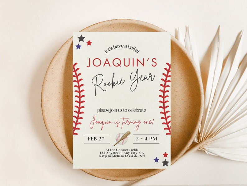 May include: Baseball-themed birthday party invitation with red stitching, a baseball, and a bat. The invitation reads "Let's have a ball at Joaquin's Rookie Year. Please join us to celebrate Joaquin is turning one! Feb 27, 2-4 PM. At the Chester Fields, 123 Anystreet, Any City, CA. RSVP to Melissa 123.456.7891."