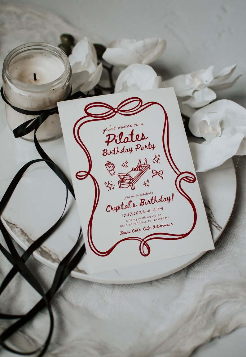 May include: A Pilates birthday party invitation with a red border and text. The invitation includes the text "Pilates Birthday Party" and "Crystal's Birthday!" A candle in a glass jar and white flowers are in the background.