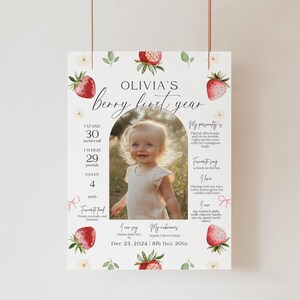 May include: A white and pink printable first birthday poster with a strawberry theme. The poster features a photo of a baby girl, along with details about her first year, including her height, weight, and favorite things. The text on the poster reads "Olivia's Berry First Year" and includes the date "Dec 23, 2024".