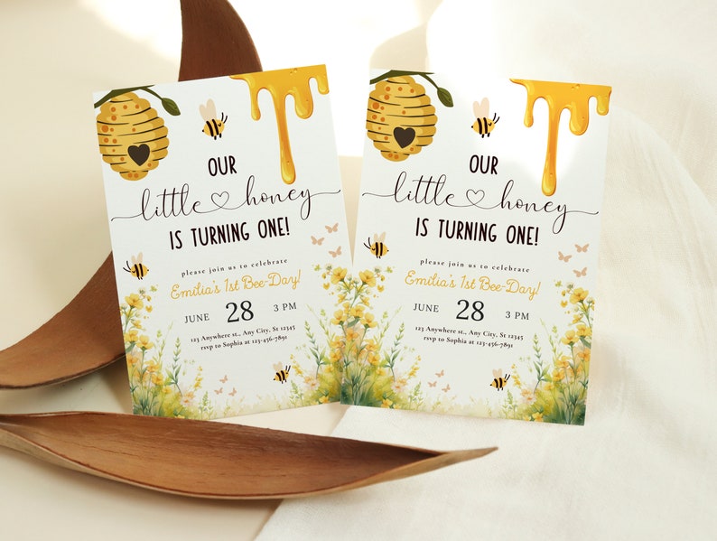 May include: A yellow and white bee-themed first birthday party invitation with a honeycomb, dripping honey, and the text "Our little honey is turning one!" and "Emilia's 1st Bee-Day!"