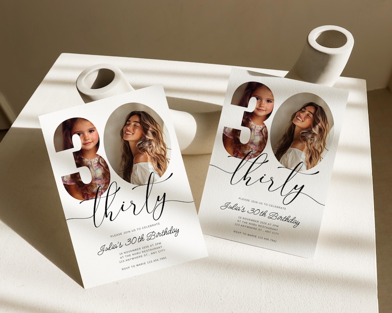 May include: White invitation card with a black and white photo of two people in a 30 cutout. The text "thirty" is written in a cursive font. The invitation reads "Please join us to celebrate Julia's 30th Birthday".