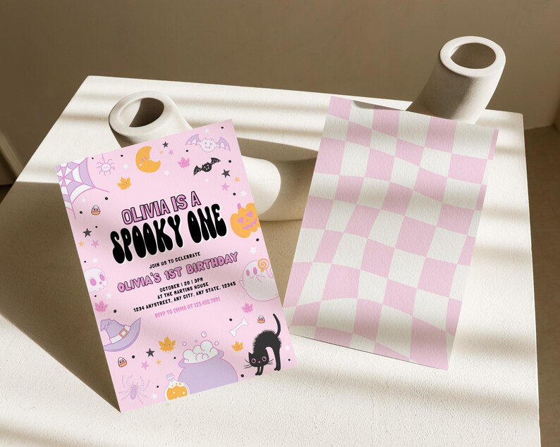 Puede incluir: Invitaci&oacute;n de cumplea&ntilde;os de Halloween de color rosa y morado con el texto "Olivia is a Spooky One" y "Olivia's 1st Birthday". La invitaci&oacute;n presenta un gato negro, un caldero, una ara&ntilde;a y otras im&aacute;genes de tem&aacute;tica de Halloween.