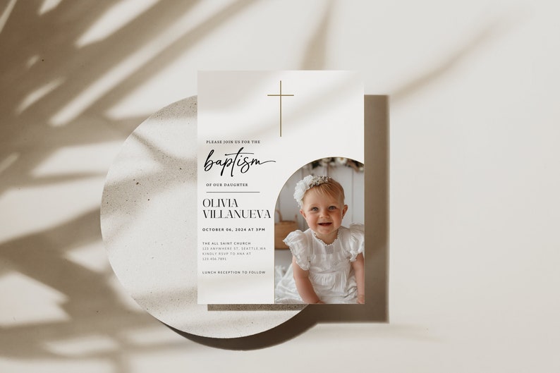 May include: A white baptism invitation with a gold cross at the top. The invitation says "Please join us for the baptism of our daughter Olivia Villanueva" and includes the date and time of the baptism. A photo of a baby girl in a white dress is in the bottom right corner of the invitation.