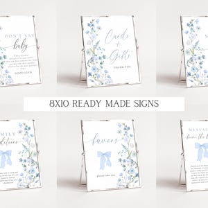 May include: Ten 8x10 inch printable signs with a blue floral design and white text. The signs include the text: "Don't Say Baby", "Cards & Gifts", "Family Traditions", "Favors", "Message from the Bump", "Mimosa Bar".
