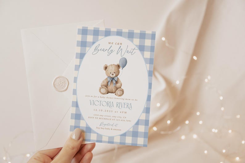 May include: Baby shower invitation with a blue gingham pattern border. The invitation features a watercolor illustration of a teddy bear holding a balloon. The text reads "We can Bearly Wait" and includes event details.