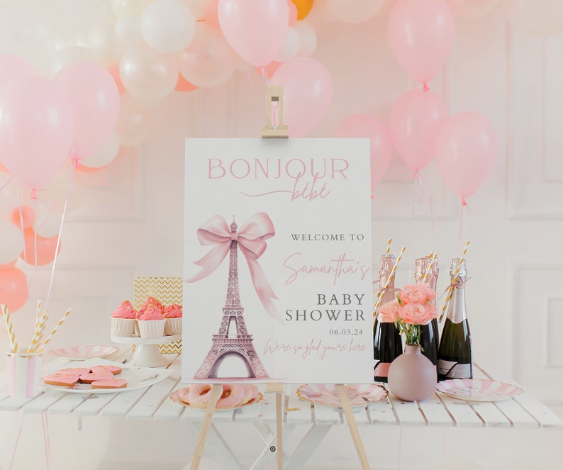 Puede incluir: Un cartel de baby shower rosa y blanco con el texto "Bonjour b&eacute;b&eacute;" y una ilustraci&oacute;n de acuarela de la Torre Eiffel con un lazo rosa. El cartel tambi&eacute;n incluye el texto "Bienvenido a la baby shower de Samantha 06.03.24 Estamos encantados de que est&eacute;s aqu&iacute;."