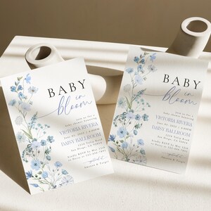Puede incluir: Invitaci&oacute;n a una fiesta de bienvenida al beb&eacute; con flores azules y blancas, con el texto "Baby in Bloom" y los detalles del evento, incluyendo la fecha, la hora y el lugar.