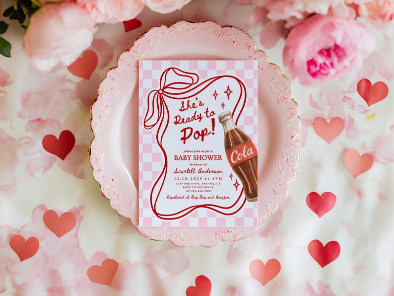 Puede incluir: Una invitaci&oacute;n para un baby shower con un dise&ntilde;o retro. La invitaci&oacute;n presenta el texto "She's Ready to Pop!" y una ilustraci&oacute;n de una botella de cola. La invitaci&oacute;n est&aacute; sobre un fondo a cuadros rosa, rodeada de corazones y flores rosas.