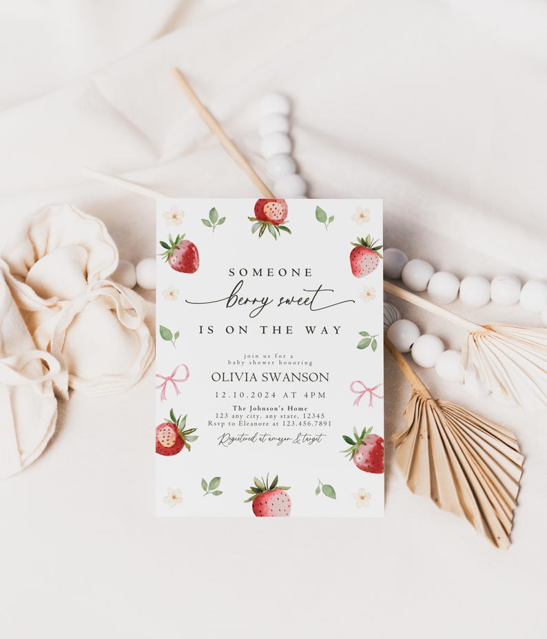 May include: A baby shower invitation with a watercolor illustration of strawberries and white flowers. The text reads "Someone berry sweet is on the way" and includes the name Olivia Swanson, the date and time of the shower, and the location.